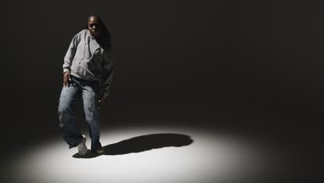 full length studio portrait shot of young woman dancing in spotlight 4