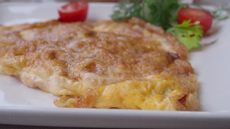 close up of an omelet with tomatoes and onions