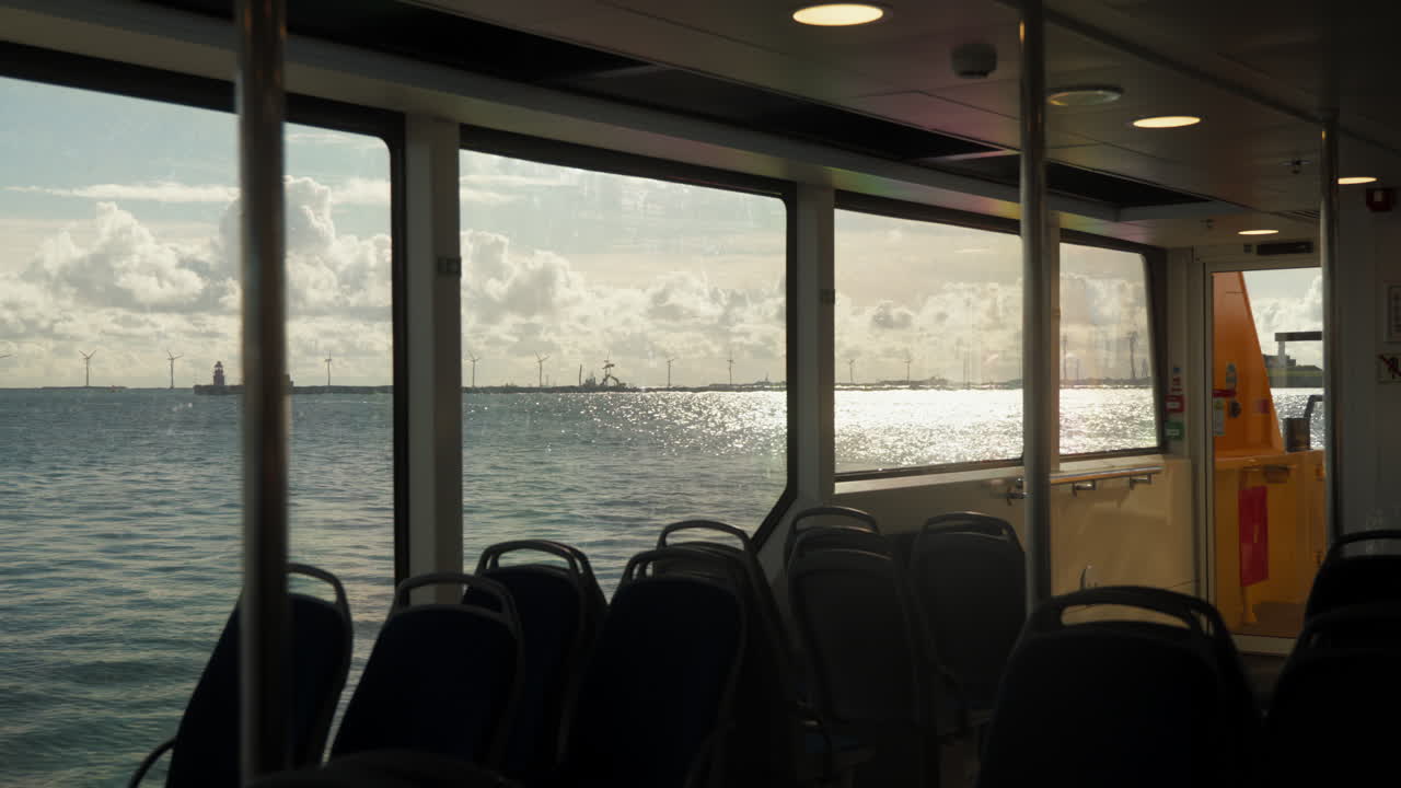 Tranquil ferry ride with scenic sea and windmill views. Perfect for travel documentaries and tourism ads.