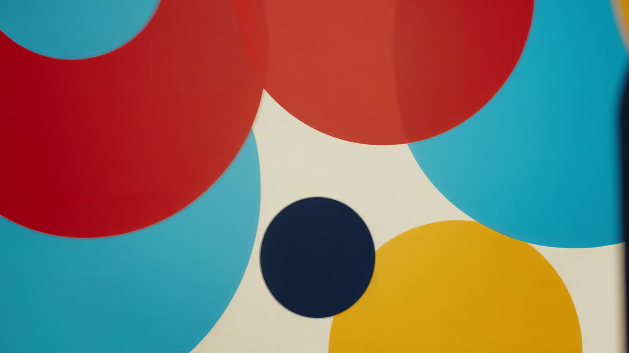 Camera panning wall panel, shifting view right then centering on colorful circles and dark elements