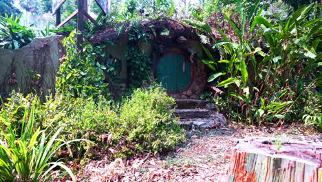 picturesque hobbit-like house with round green door and small garden