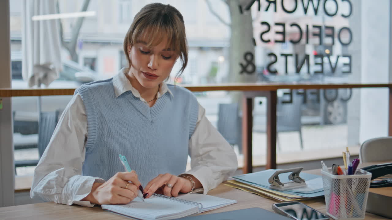 Business woman taking notes writing notebook in cafe closeup. Lady putting marks