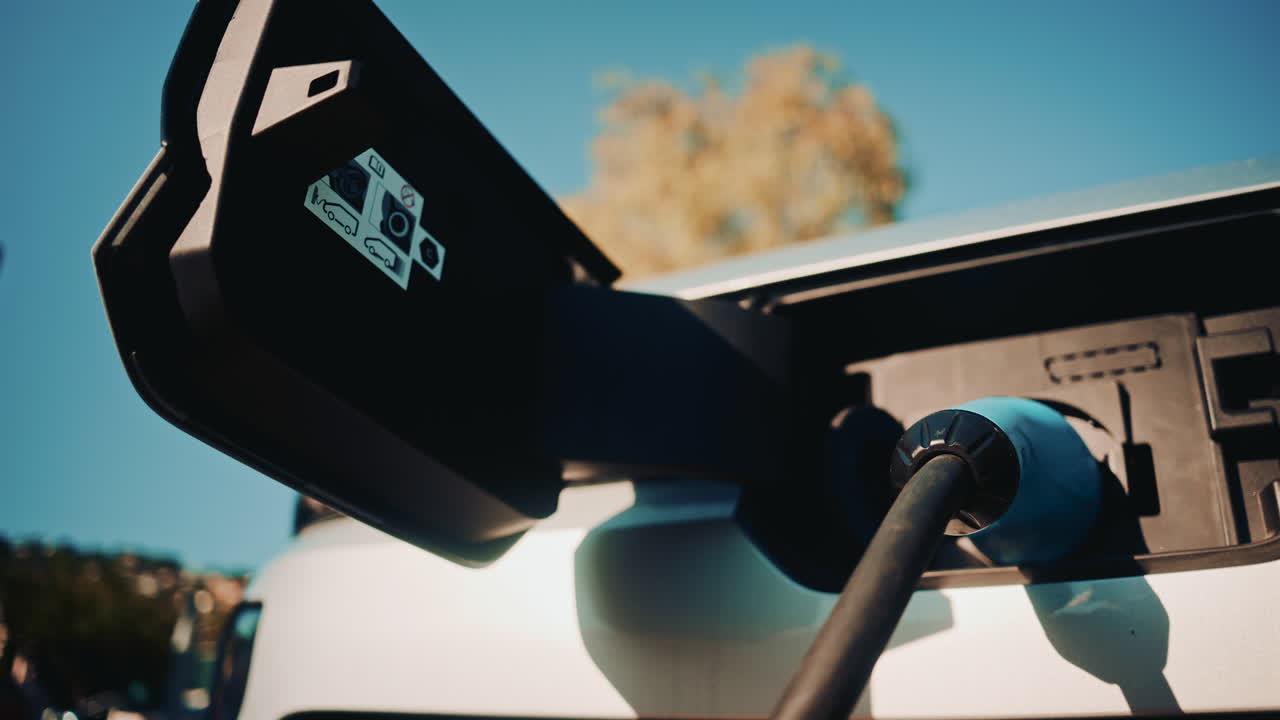 Close up shot of an electric vehicle charging port with cable connected
