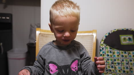 happy kid eating a meal at the kitchen table