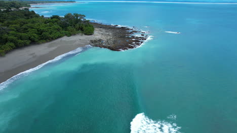 Vista-Aérea-De-Drones-De-La-Costa-Tropical-Con-Playa-De-Arena-Y-Agua-Turquesa-En-Costa-Rica