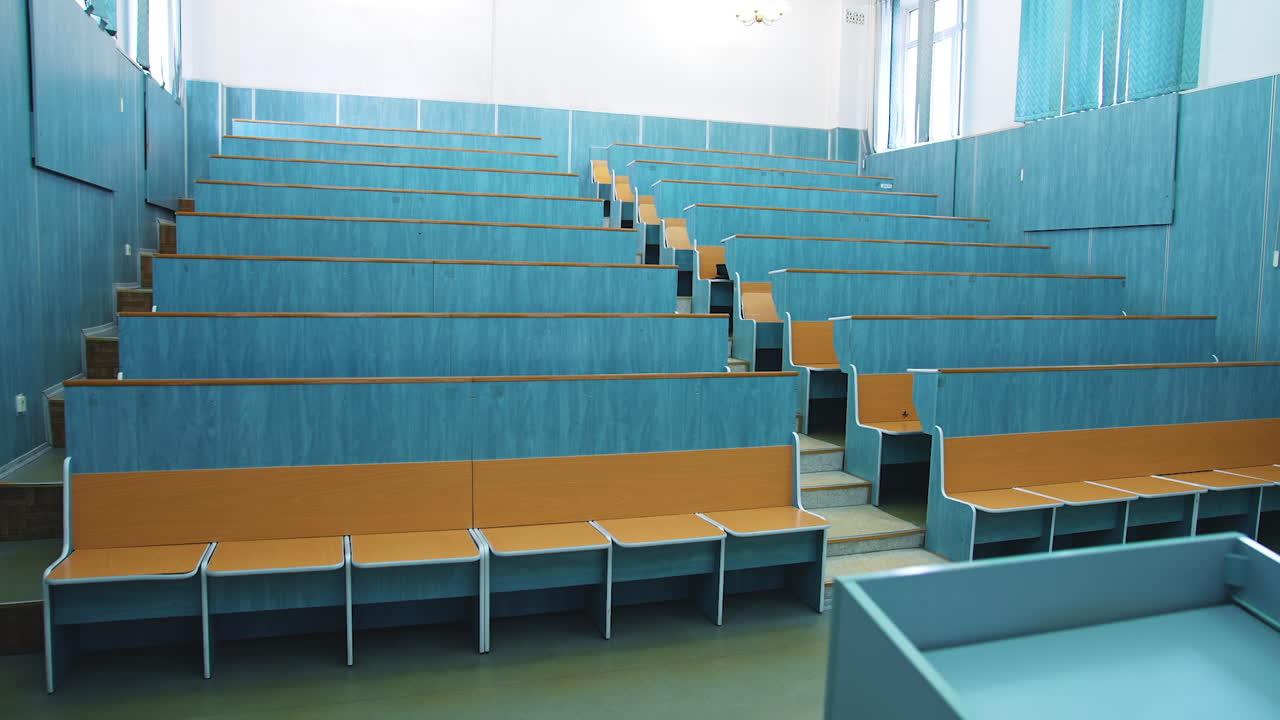 Auditorium For Lectures At University. Empty auditorium with wooden desks and chairs