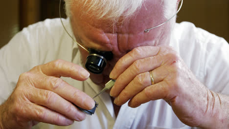 close-up of horologist repairing a watch