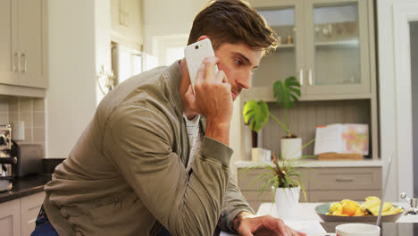 Worried-man-talking-on-phone-while-using-his-laptop-4K-4k