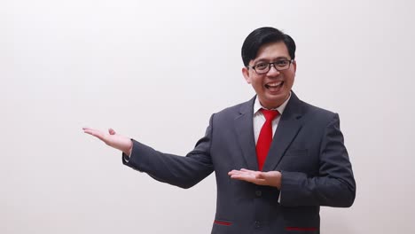 happy asian businessman standing while presenting sideways