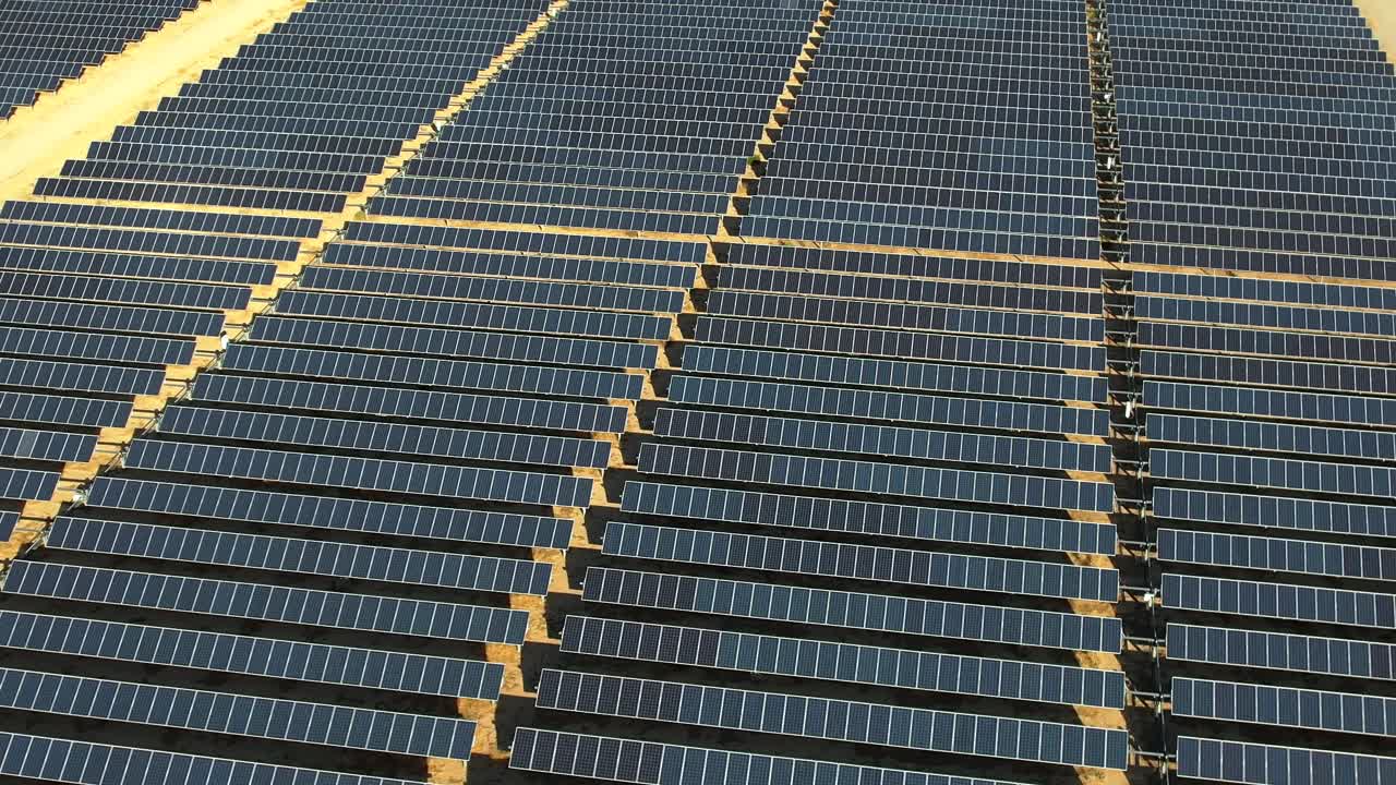 vista aérea orbitando vastos paneles solares de mojave matriz de energía renovable que se refleja en la luz del sol