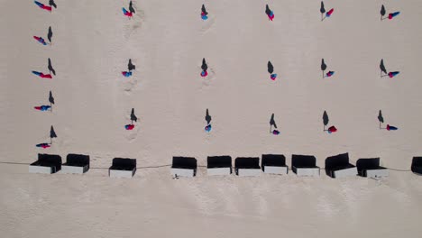 aérea de arriba hacia abajo, filas de sombrillas de playa cerradas durante el verano
