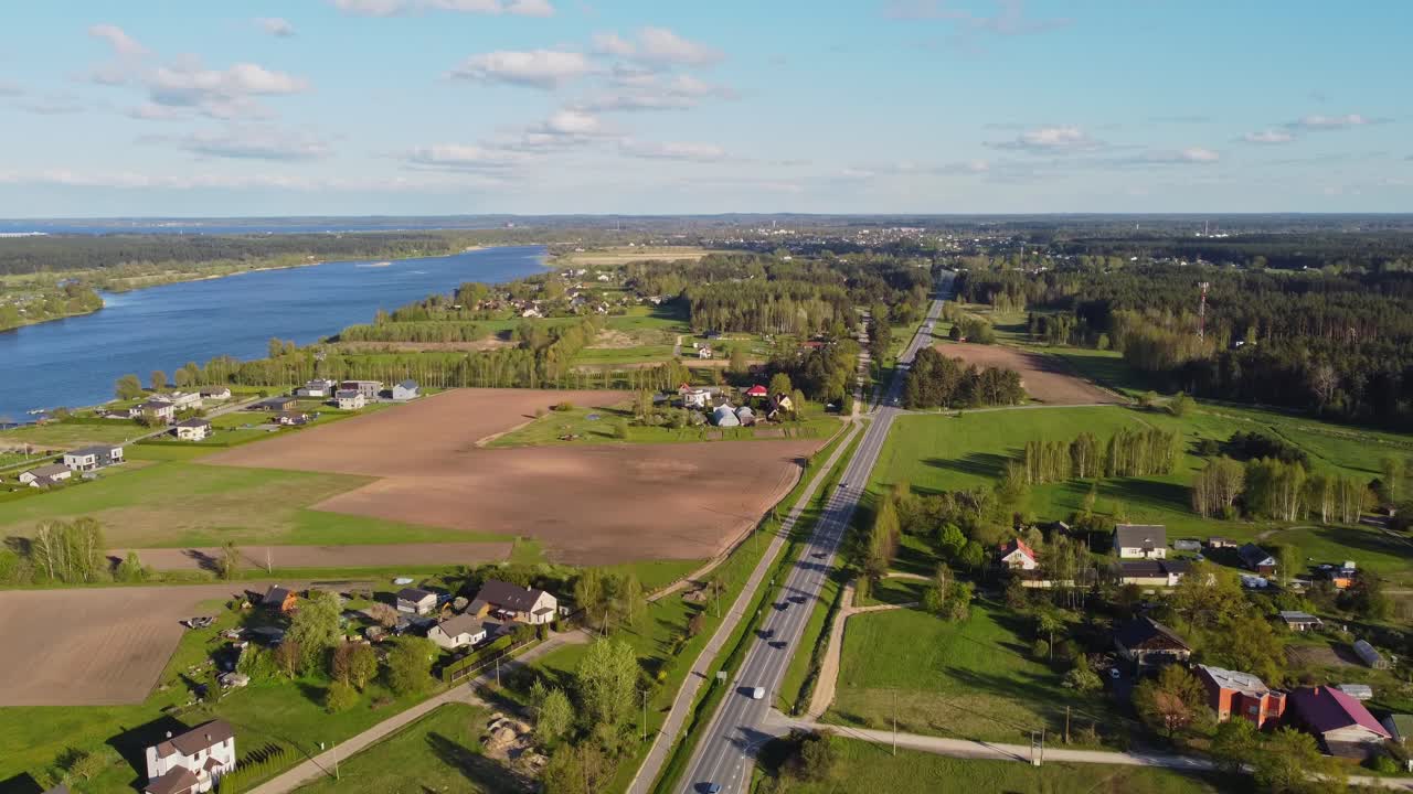 Katlakalns Spring Residential Area near a big river, with visible street traffic activity.