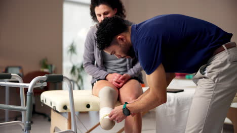 physical therapist measures the leg of a patient with a prosthetic leg