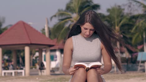lady in tight dress with long loose flowing hair reads book