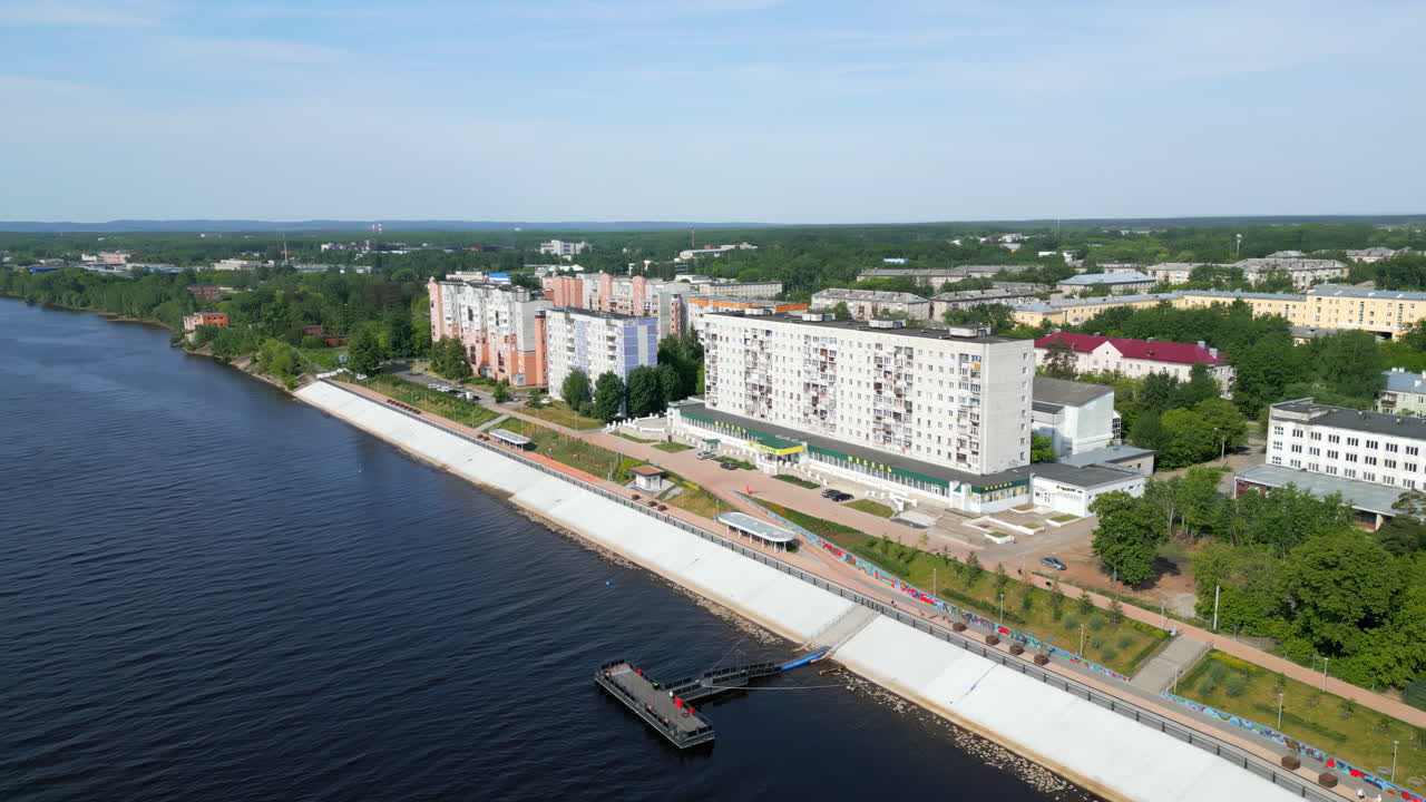 Aerial view of a city along a river with an embankment and residential buildings