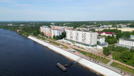 aerial view of a city along a river with an embankment and residential buildings