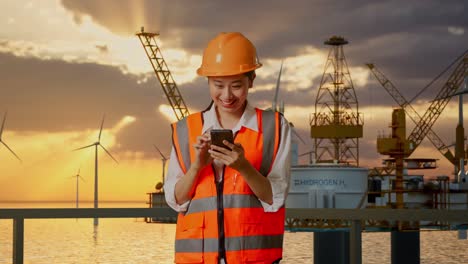 woman engineer using smartphone on oil rig