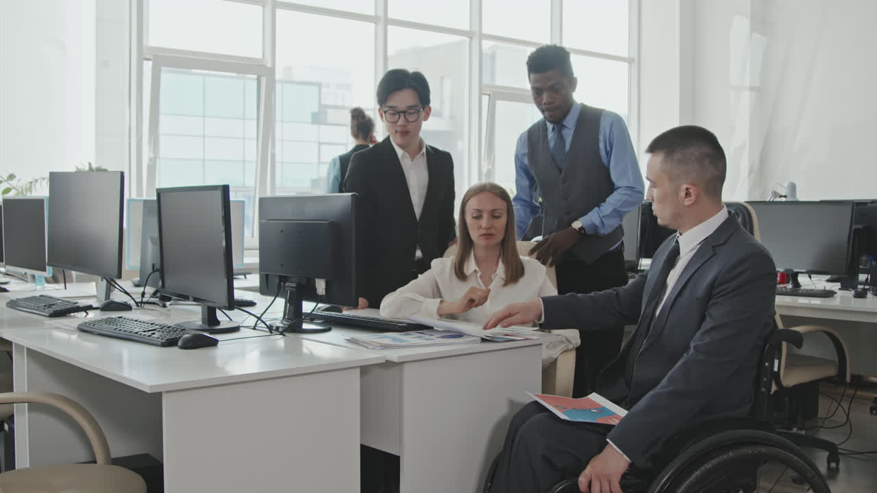 Executive in Wheelchair Discussing Work with Colleagues