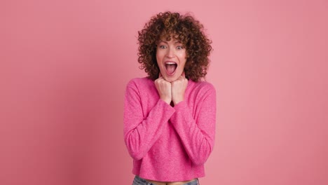 stunned young woman standing with opened mouth on pink background