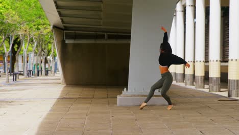 female dancer dancing under a bridge in the city 4k