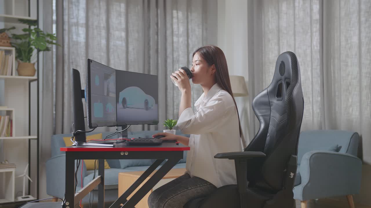 아시아 여성 자동차 디자이너가 스튜디오의 데스크 컴퓨터에서 ev 자동차의 3d 모델을 작업하는 동안 커피를 마시고 있는 측면 시각
