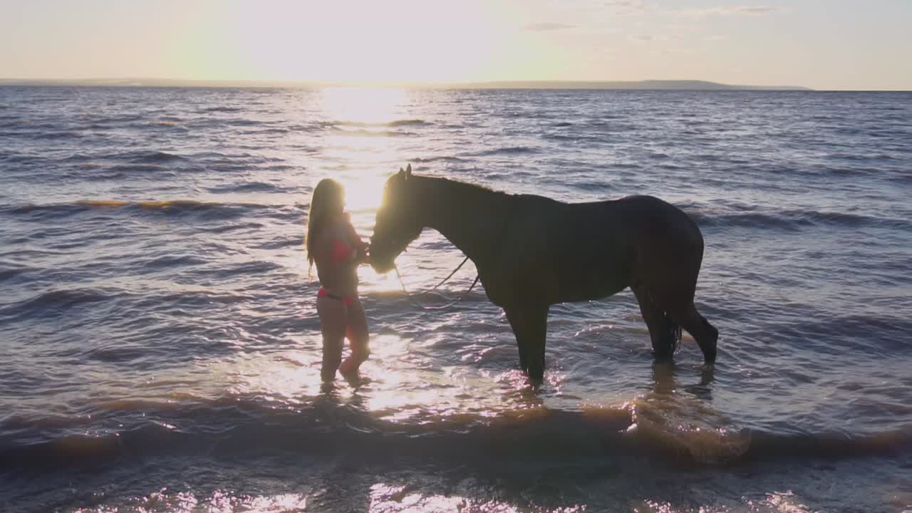 mulher e cavalo a tomar banho no lago ao pôr do sol