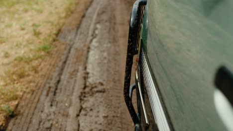 POV-shot-on-side-of-driving-safari-vehicle-of-muddy-dirt-road-in-Africa