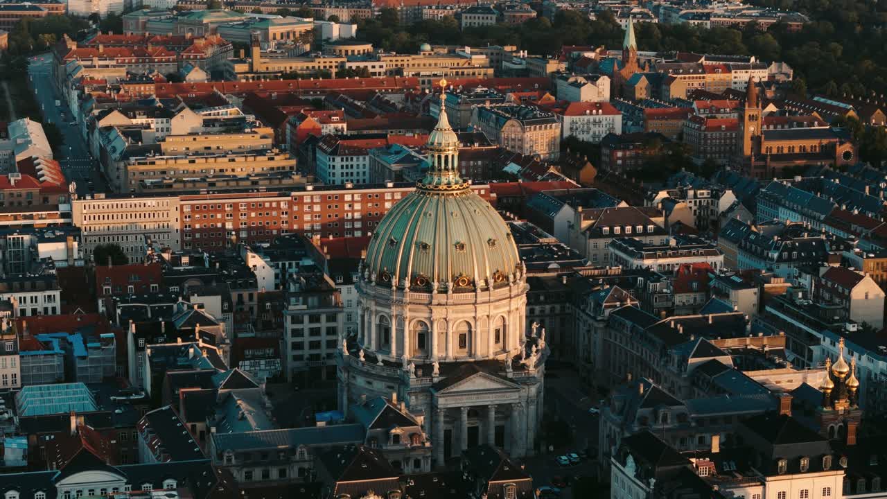 Aerial circling view of Frederiks Kirke church at sunrise, half dome in shadow