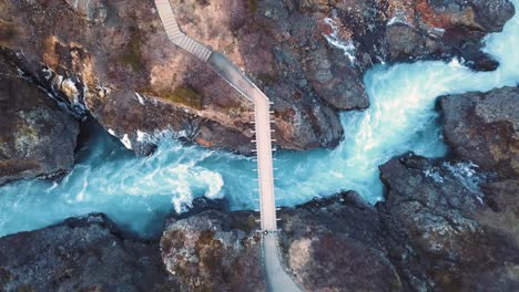 drone with cinematic movements shows beautiful icelandic waterfall, hraunfossar, in sunset light from multiple angles