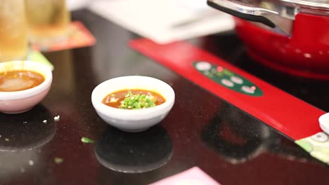 hand stirring sauce in a small bowl