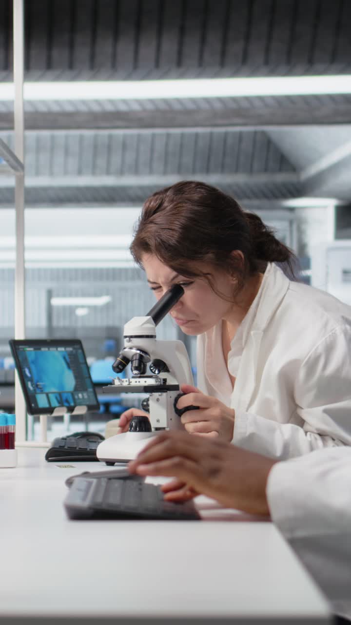 Vertical video Portrait of happy scientist using computer program for DNA data analysis