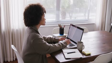 woman working on laptop while sitting at table