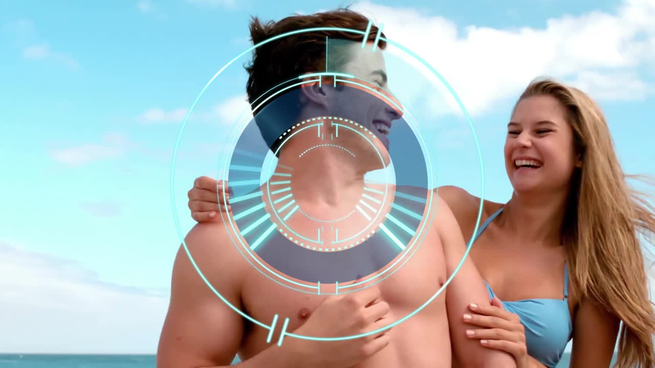 At beach, couple smiling with digital target animation overlay in background