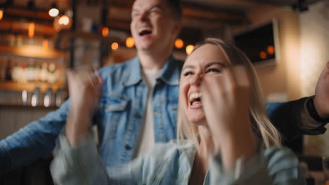 Primer-Plano-De-Una-Mujer-Joven-Y-Bonita-Viendo-Un-Partido-De-Fútbol-En-La-Televisión-Con-Amigos-Y-Decepcionándose-Por-El-Fracaso-Del-Equipo.-Mujeres-Sentadas-Entre-La-Multitud-En-Un-Evento-Deportivo.