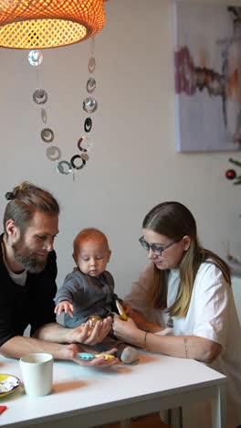familia feliz jugando con adornos de navidad