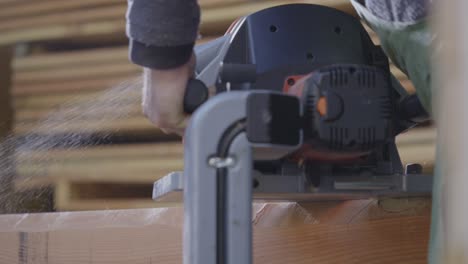 Slow-Motion-Shot-Of-Hand-Cutting-Wood-Carefully,-Dust-Flying-In-Air