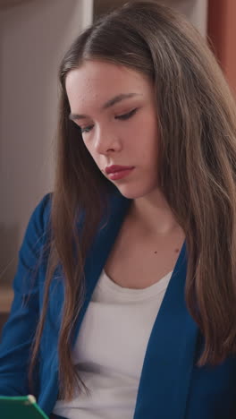 businesswoman marks notes on clipboard in office. thoughtful woman in formal clothes checks tasks in to do list at workplace. corporate lifestyle