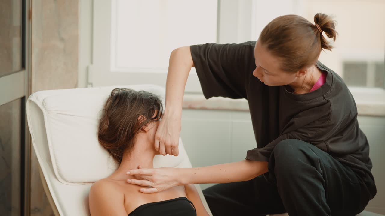 Žena dostává relaxační masáž obličeje a krku od terapeuta.