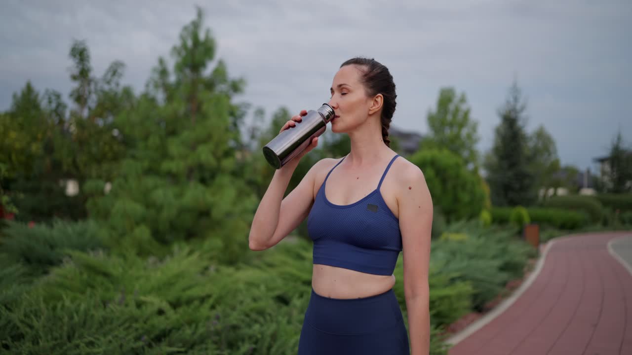 mujer bebiendo agua al aire libre