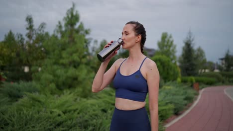 woman drinking water outdoors