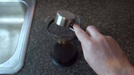sacar café molido en una cafetera de prensa francesa