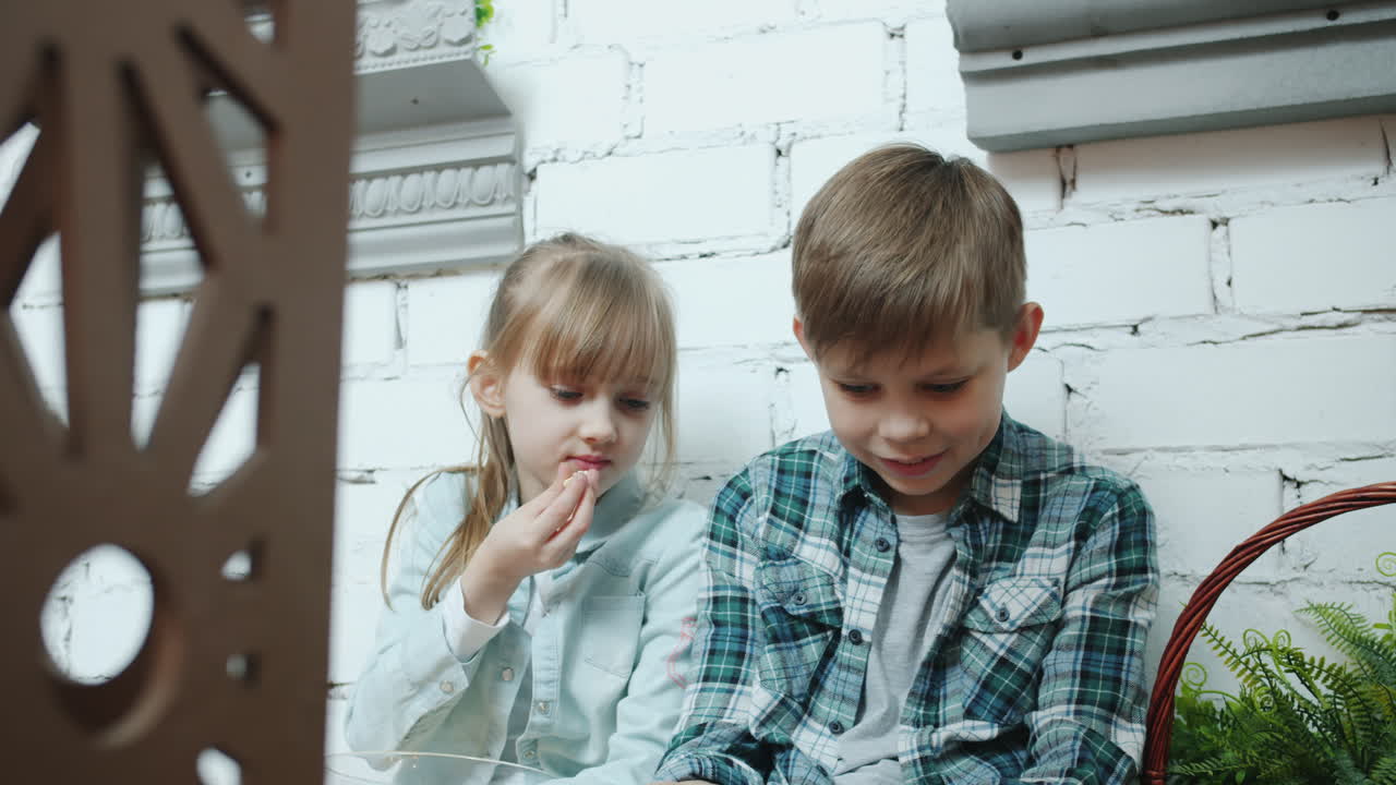 Children Eating Popcorn and Watching Phone