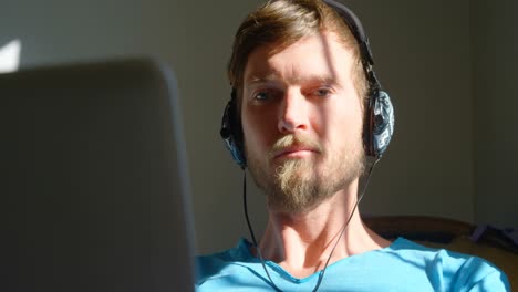 man using laptop with headphones 4k