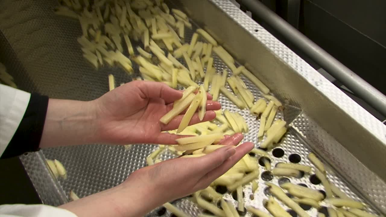 manos recogiendo papas fritas con manchas negras