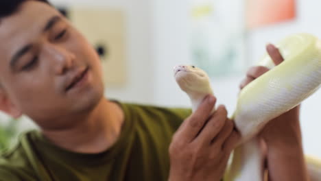 man holding snake indoors