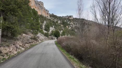 POV-driving-along-a-mountain-road-next-to-a-river