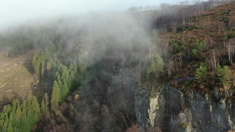 aerial view, morning fog above steep rocky cliffs and autumn landscape in rural norway