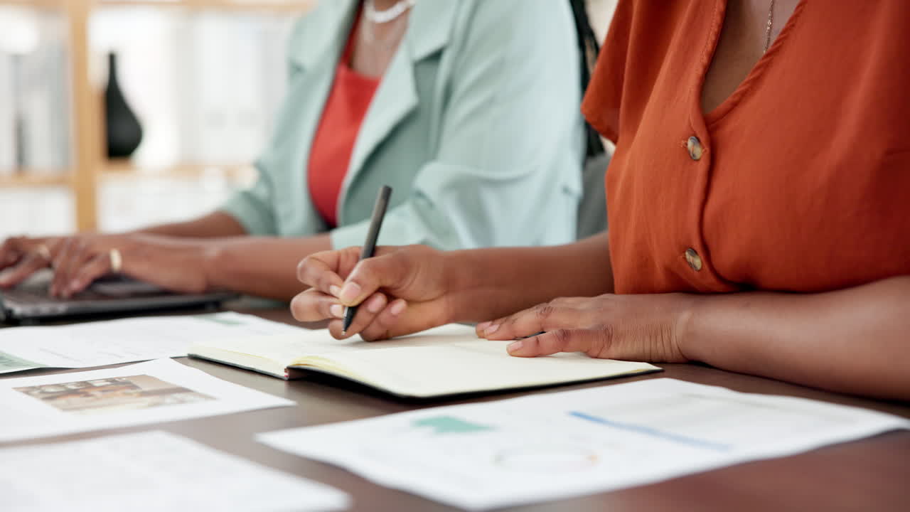 Close-Up of Businesswomen Writing and Typing at Office Desk