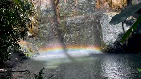 colorful rainbow forms over a cascading waterfall