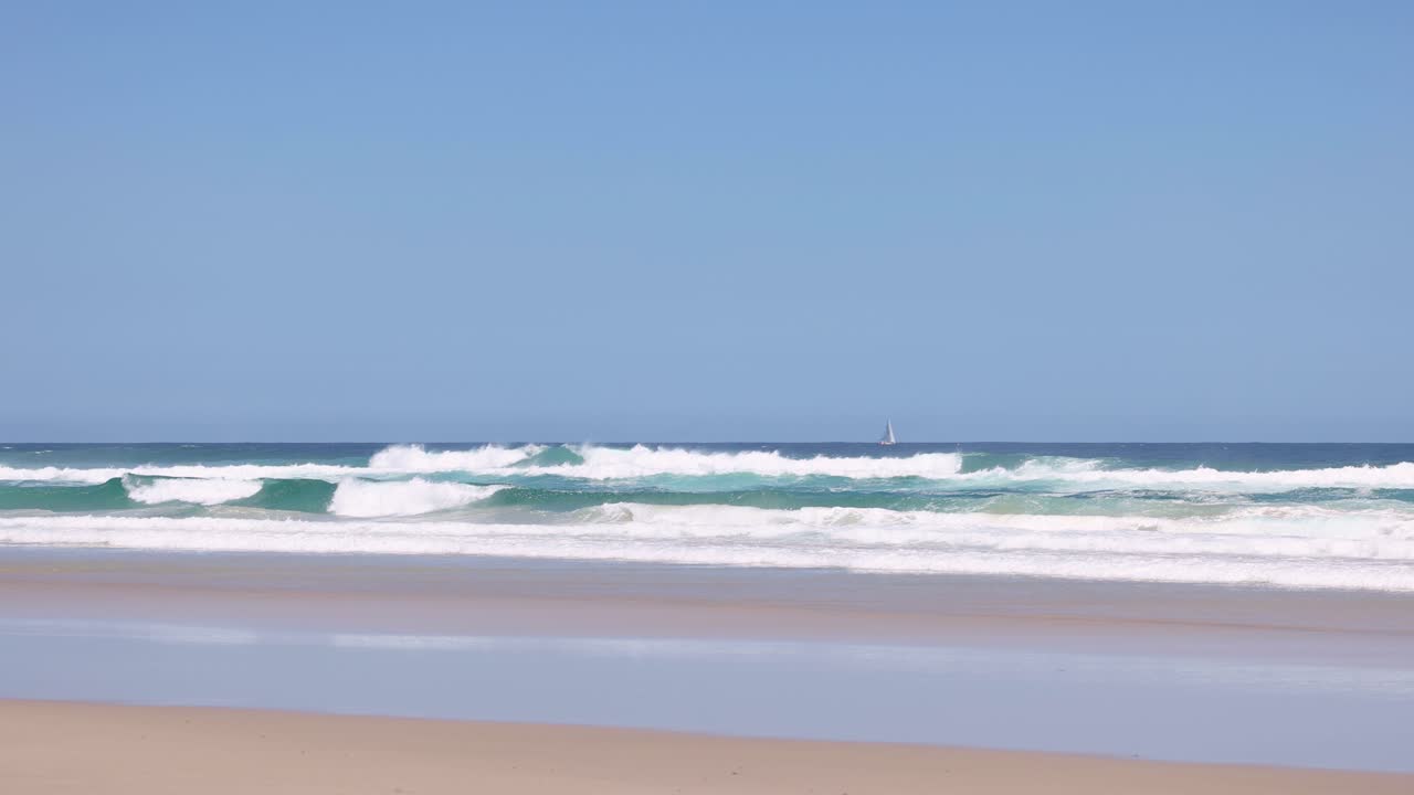 평온한 바다의 파도가 부드럽게 모래 해변에 다가오고 있습니다.